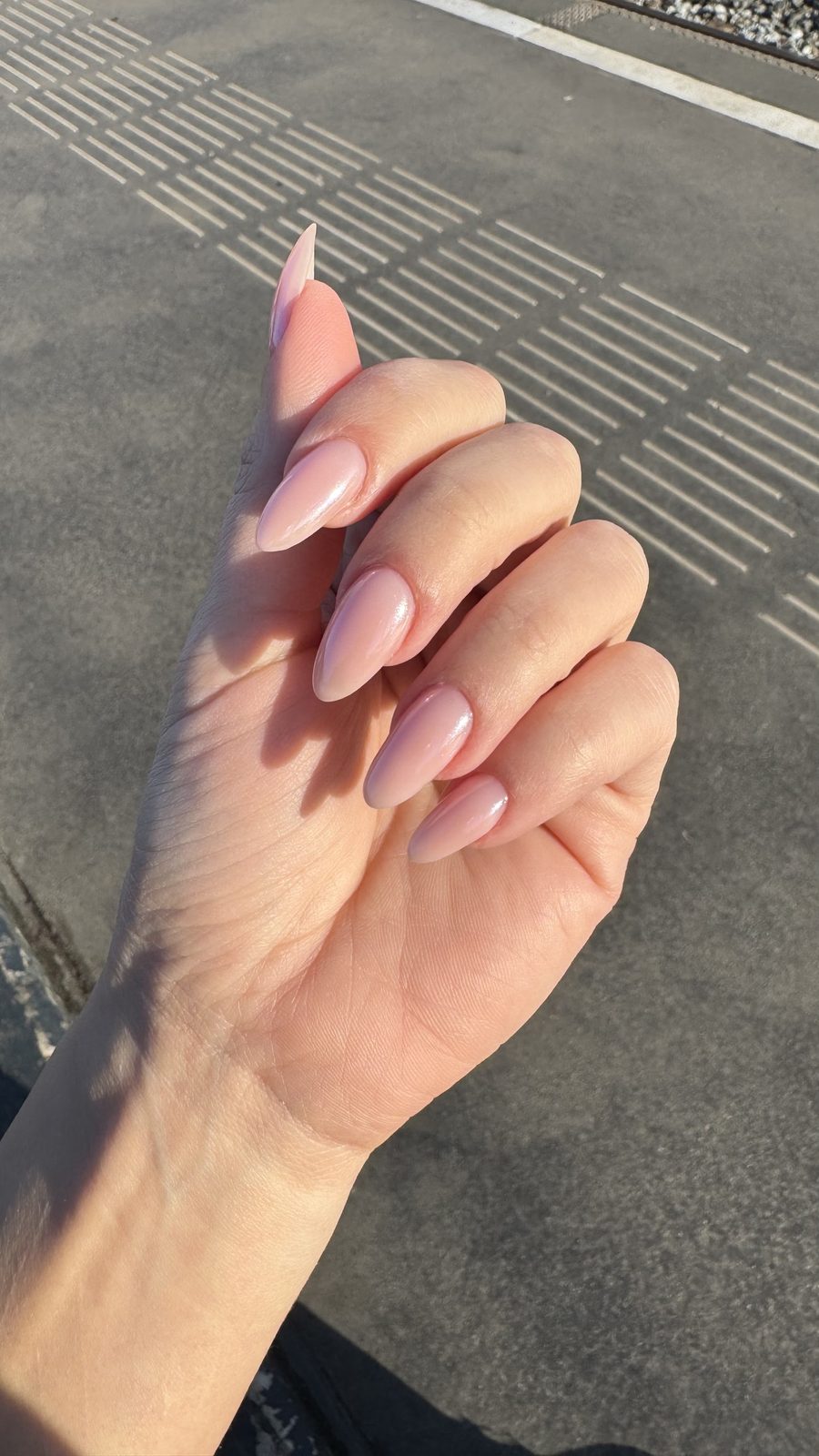Lange amandelvormige nude nagels, buiten op straat