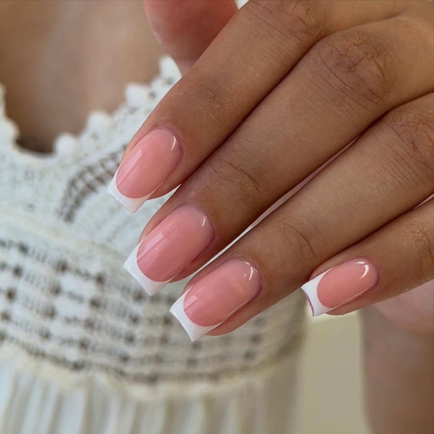Roze vierkante nagels met een witte French tip voor een witte kanten top